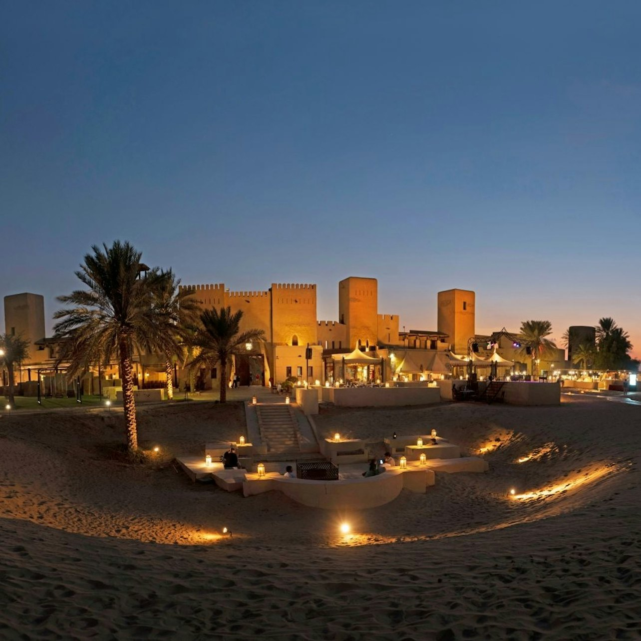 Experience the magic of the desert night where a majestic fortress meets the tranquility of starlit skies inviting exploration and adventure amidst the serene Arabian landscape.